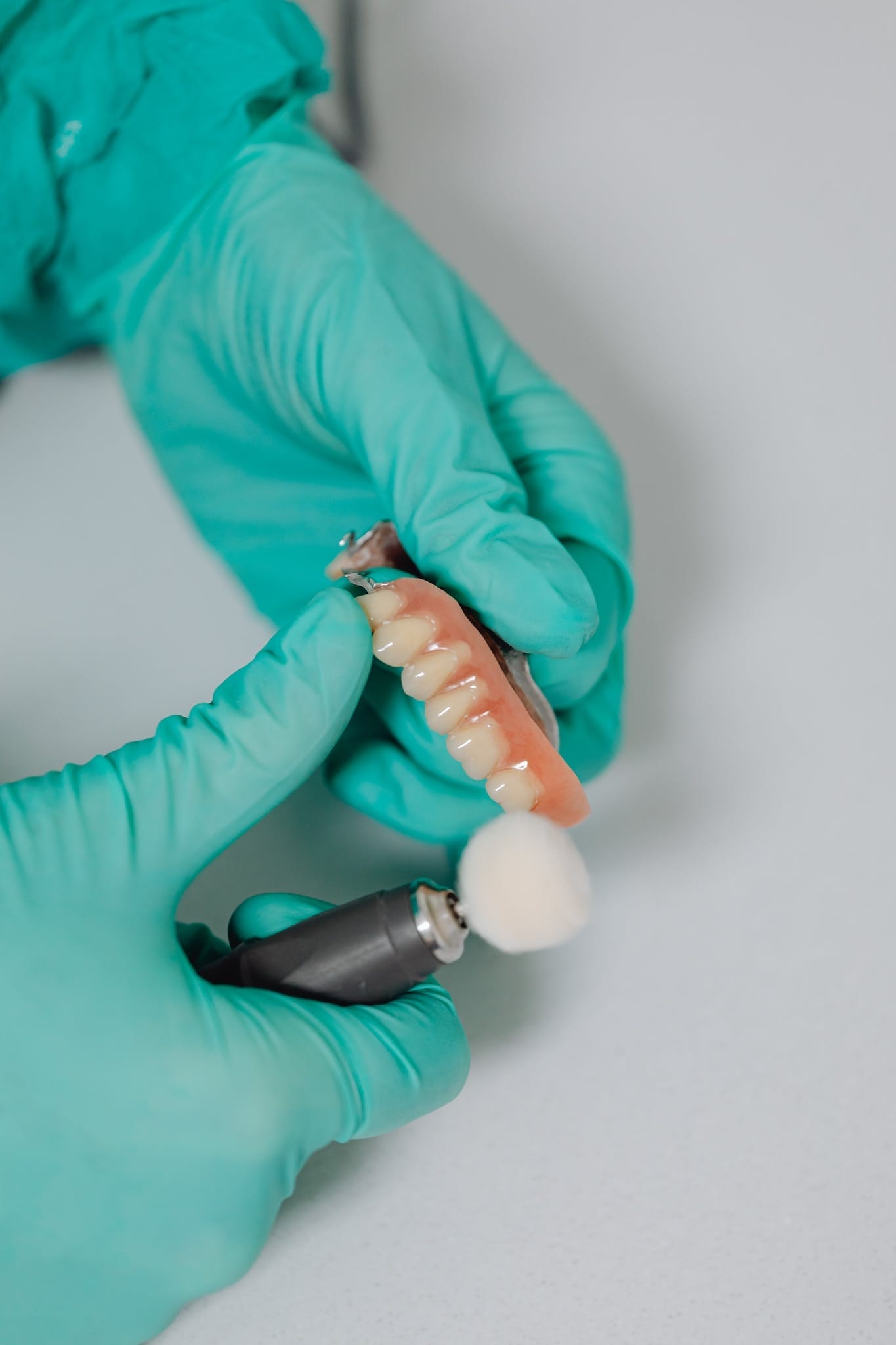 Full and Partial Dentures A Close-Up Shot of a Person Polishing a Denture. Ivy Lane Dentistry offers full and partial dentures in San Antonio, TX.